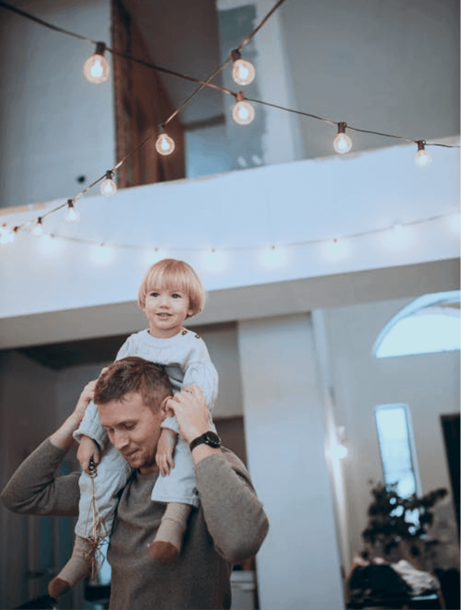 Ein Vater hat sein glückliches Kind auf den Schultern